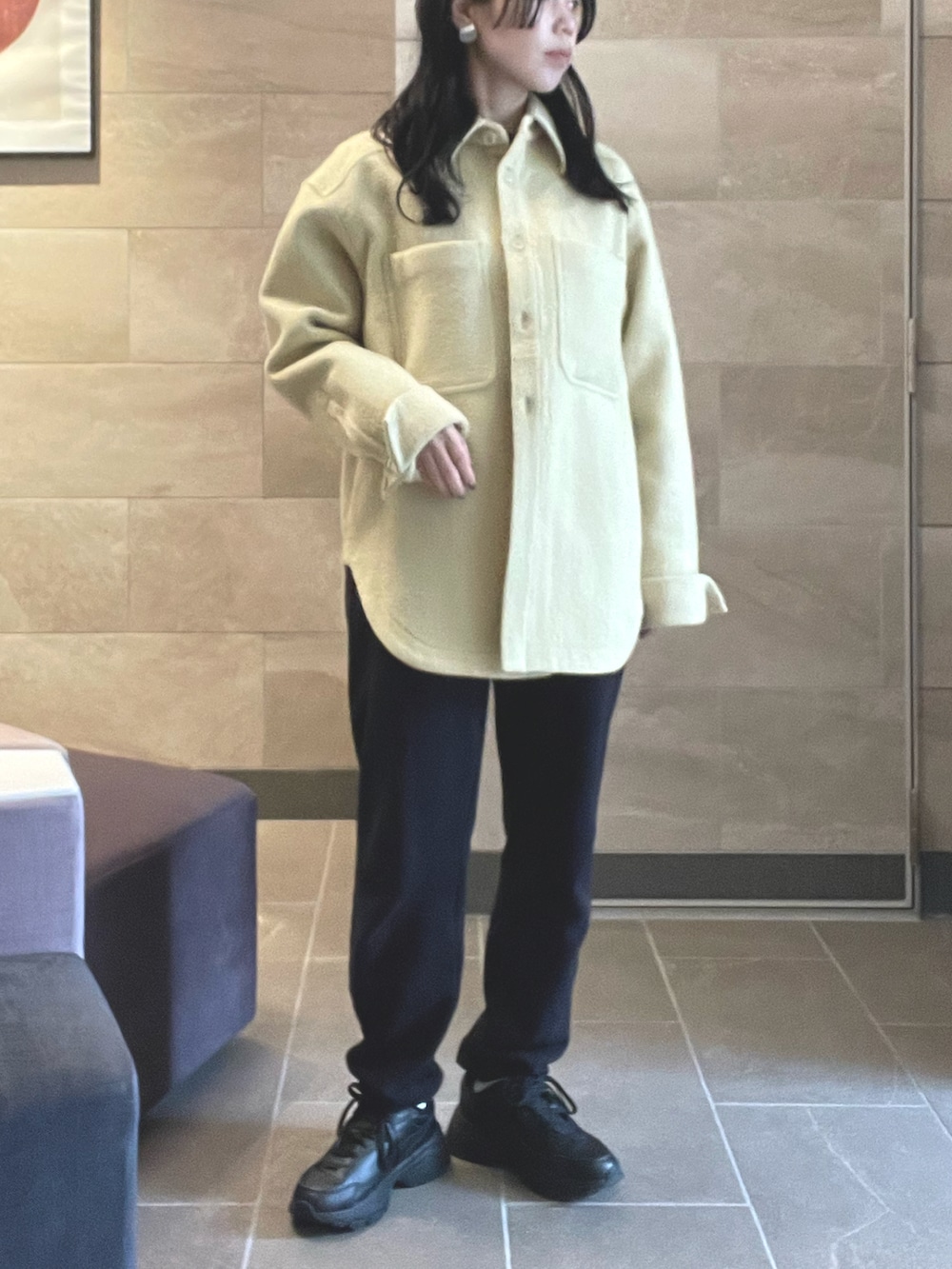 ブラック系のスウェットパンツ、ベージュ系のテーラードジャケット、ブラック系のスニーカーを着用したレディースの春コーディネートの2枚目の写真