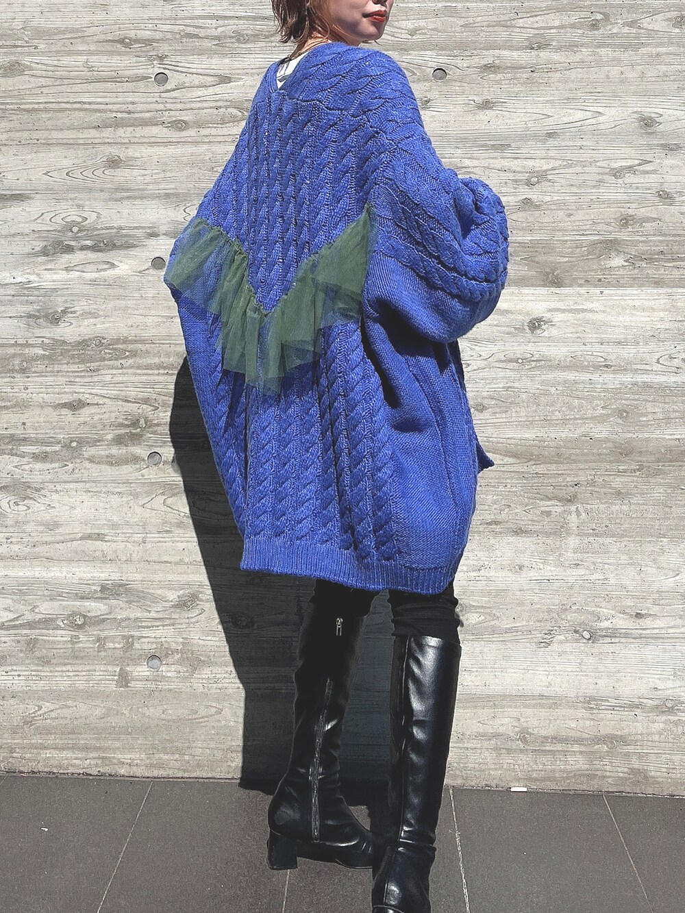 ブルー系のカーディガン/ボレロ、ブラック系のブーツ、ブラック系のパンツを着用したレディースの春コーディネートの2枚目の写真