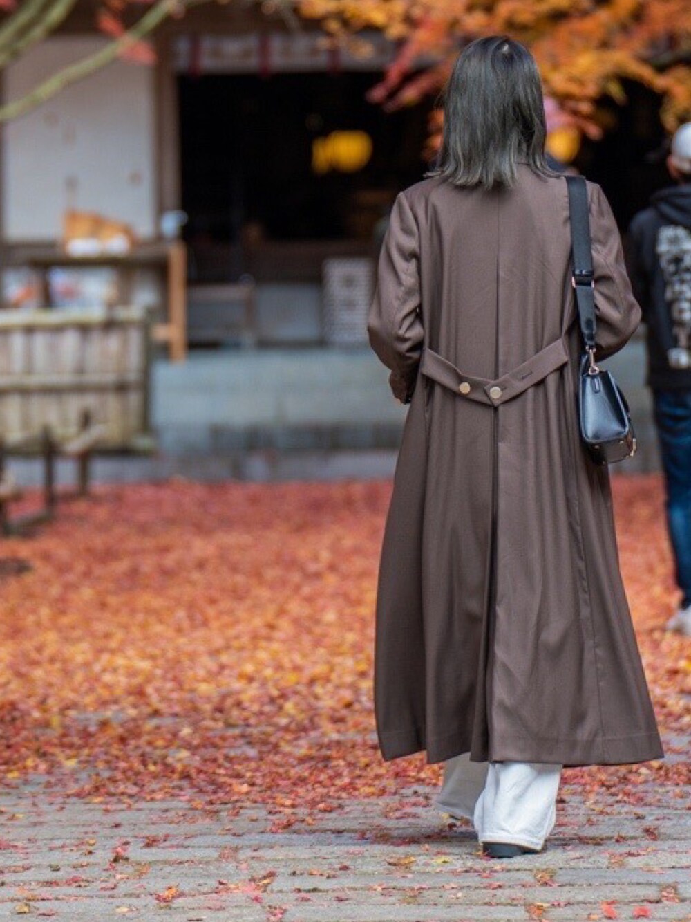 ブラウン系のテーラードジャケット、ホワイト系のパンツ、ブラック系のドレスシューズを着用したレディースの冬コーディネートの3枚目の写真