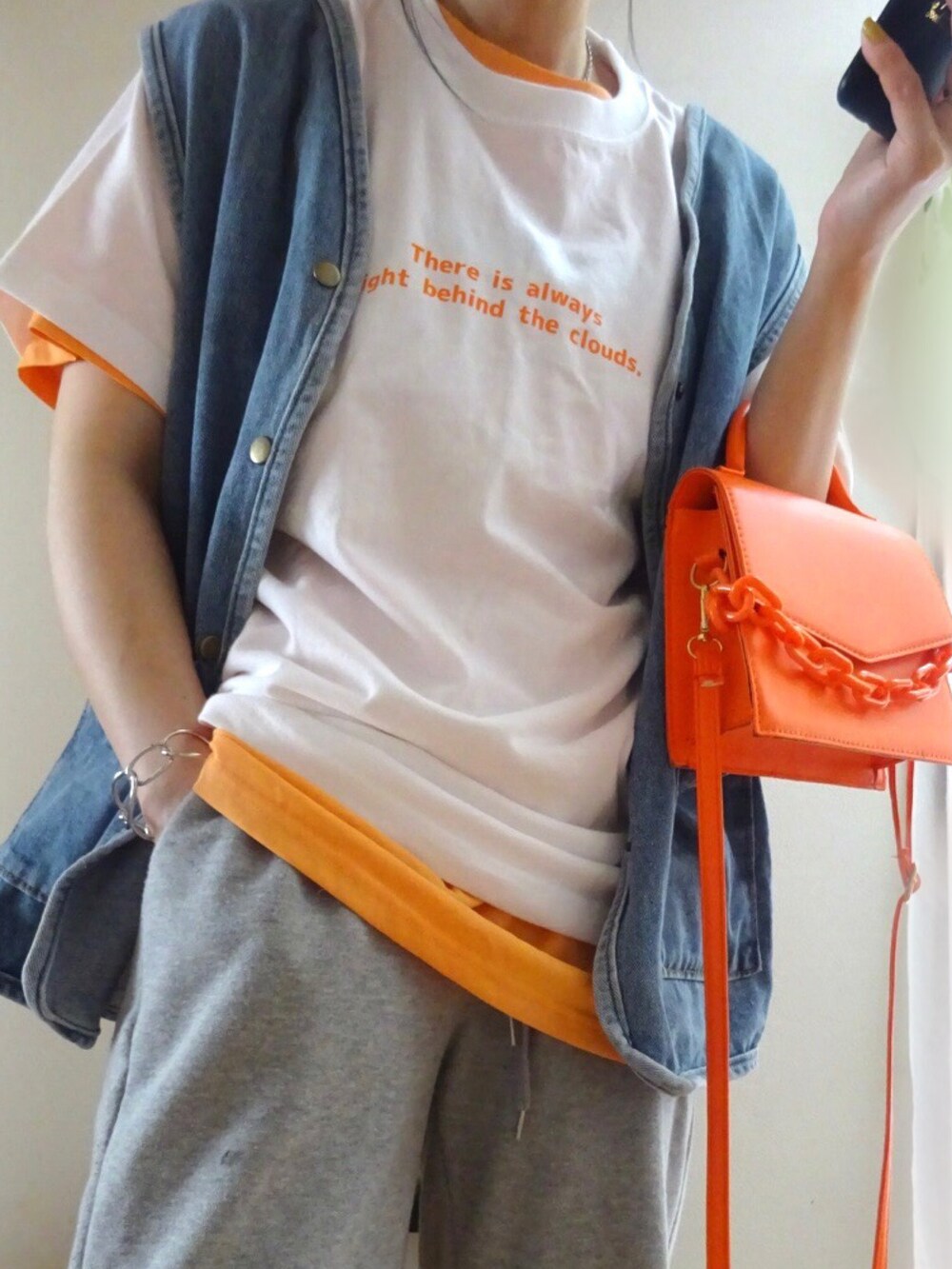 グレー系のその他パンツ、オレンジ系のショルダーバッグ、オレンジ系のTシャツ/カットソーを着用したレディースの春コーディネートの3枚目の写真