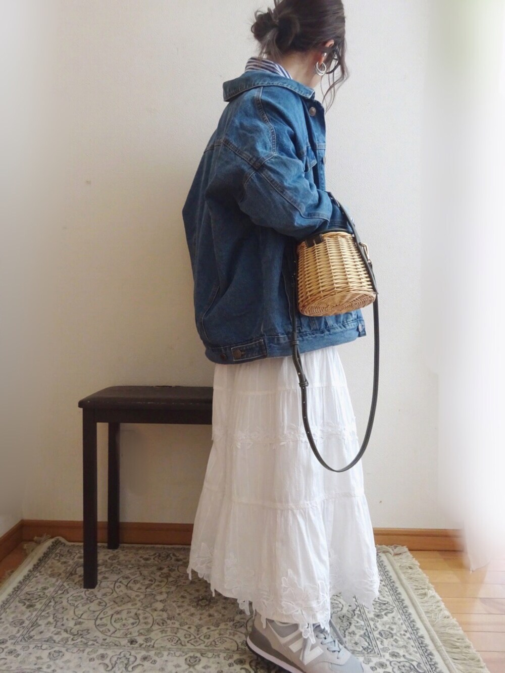ブルー系のデニムジャケット、ホワイト系のスカート、ベージュ系のバッグを着用したレディースの春コーディネートの2枚目の写真