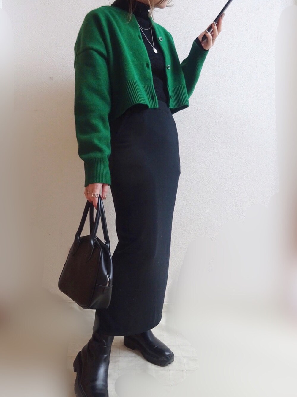 グリーン系のカーディガン/ボレロ、ブラック系のブーツ、ブラック系のトートバッグを着用したレディースの冬コーディネートの2枚目の写真