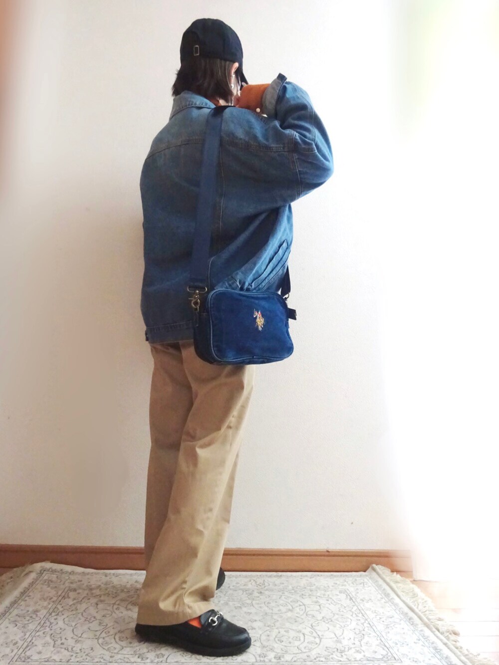 ブルー系のデニムジャケット、ベージュ系のチノパンツ、ブラック系のローファーを着用したレディースの冬コーディネートの2枚目の写真