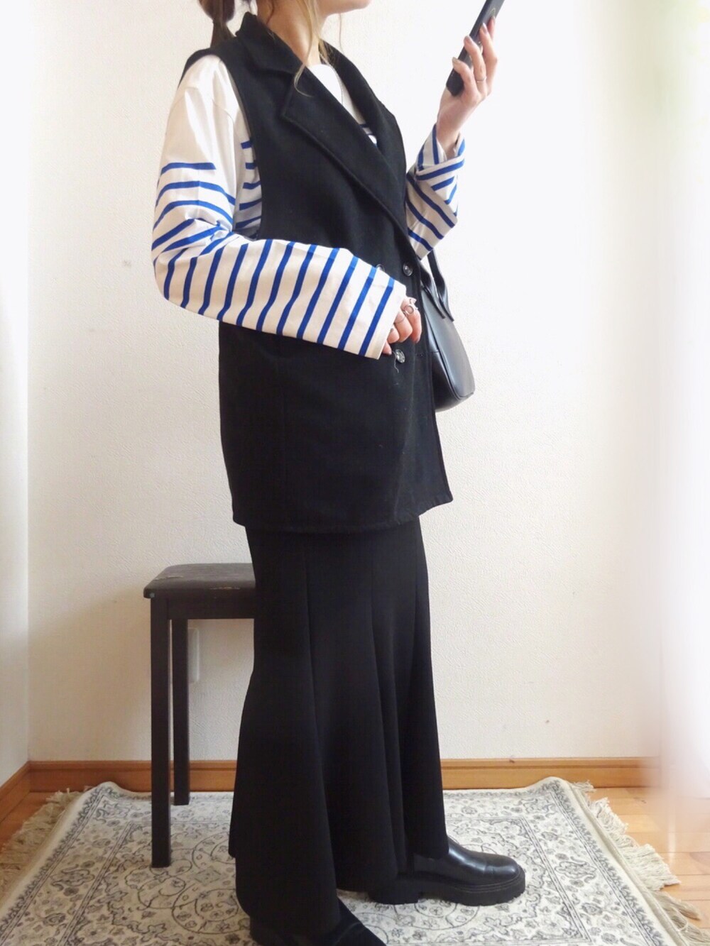 ブラック系のトートバッグ、ブルー系のTシャツ/カットソー、ブラック系のスカートを着用したレディースの冬コーディネートの2枚目の写真