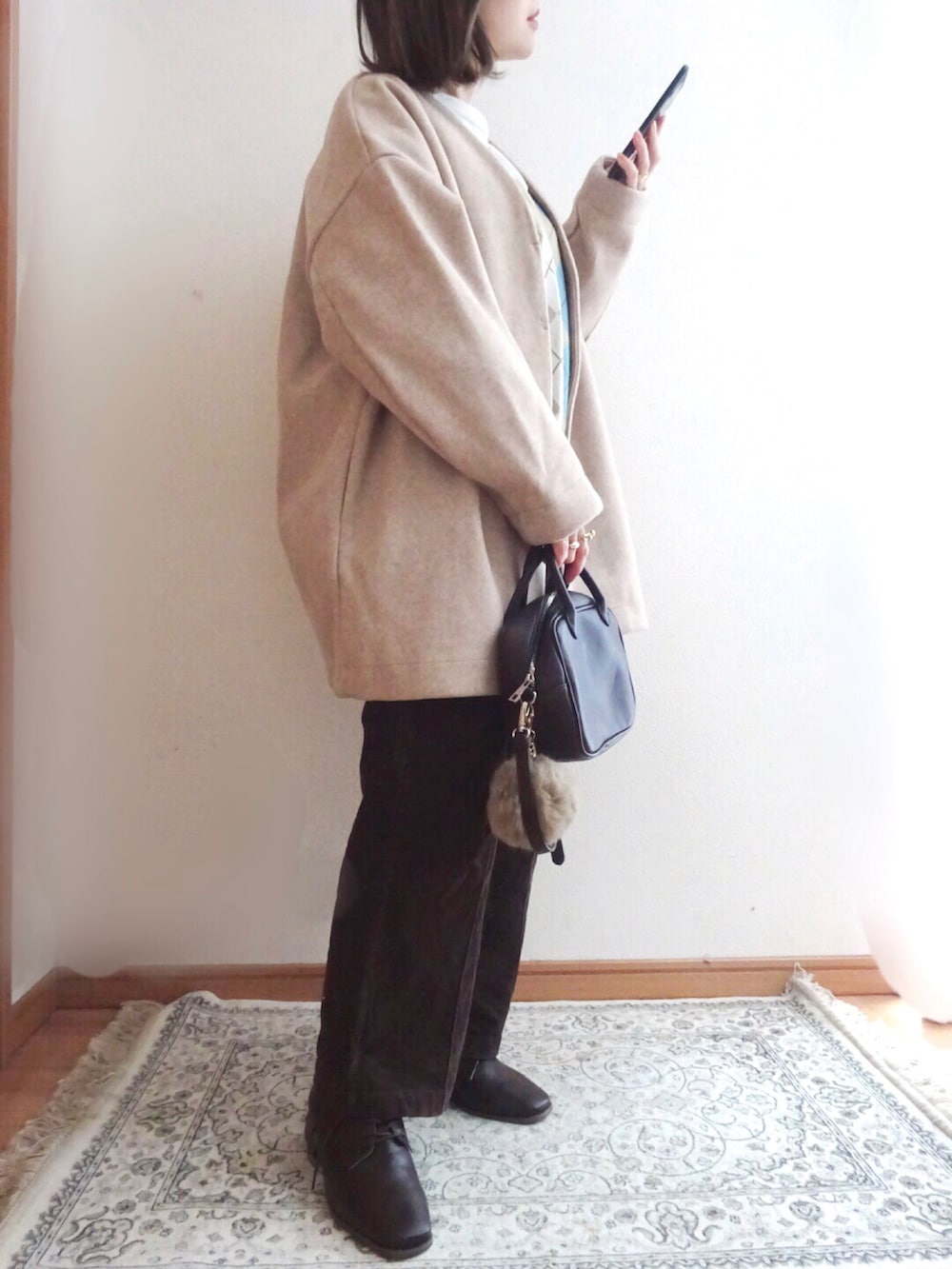 ピンク系のノーカラーコート、ベージュ系のニット/セーター、ブラウン系のその他パンツを着用したレディースの冬コーディネートの2枚目の写真