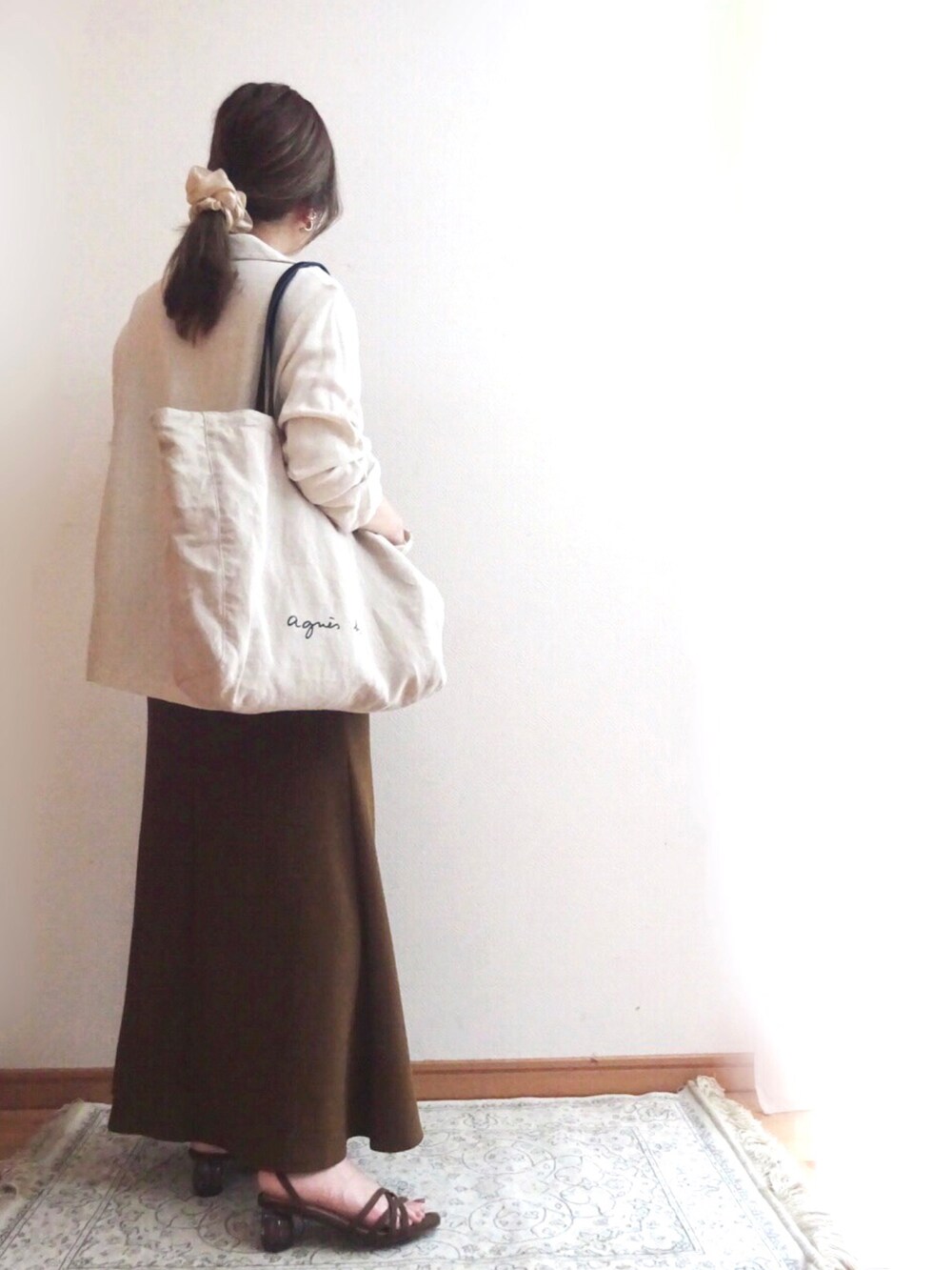 ブラック系のキャミソール、ブラック系のトートバッグ、ブラウン系のスカートを着用したレディースの夏コーディネートの3枚目の写真