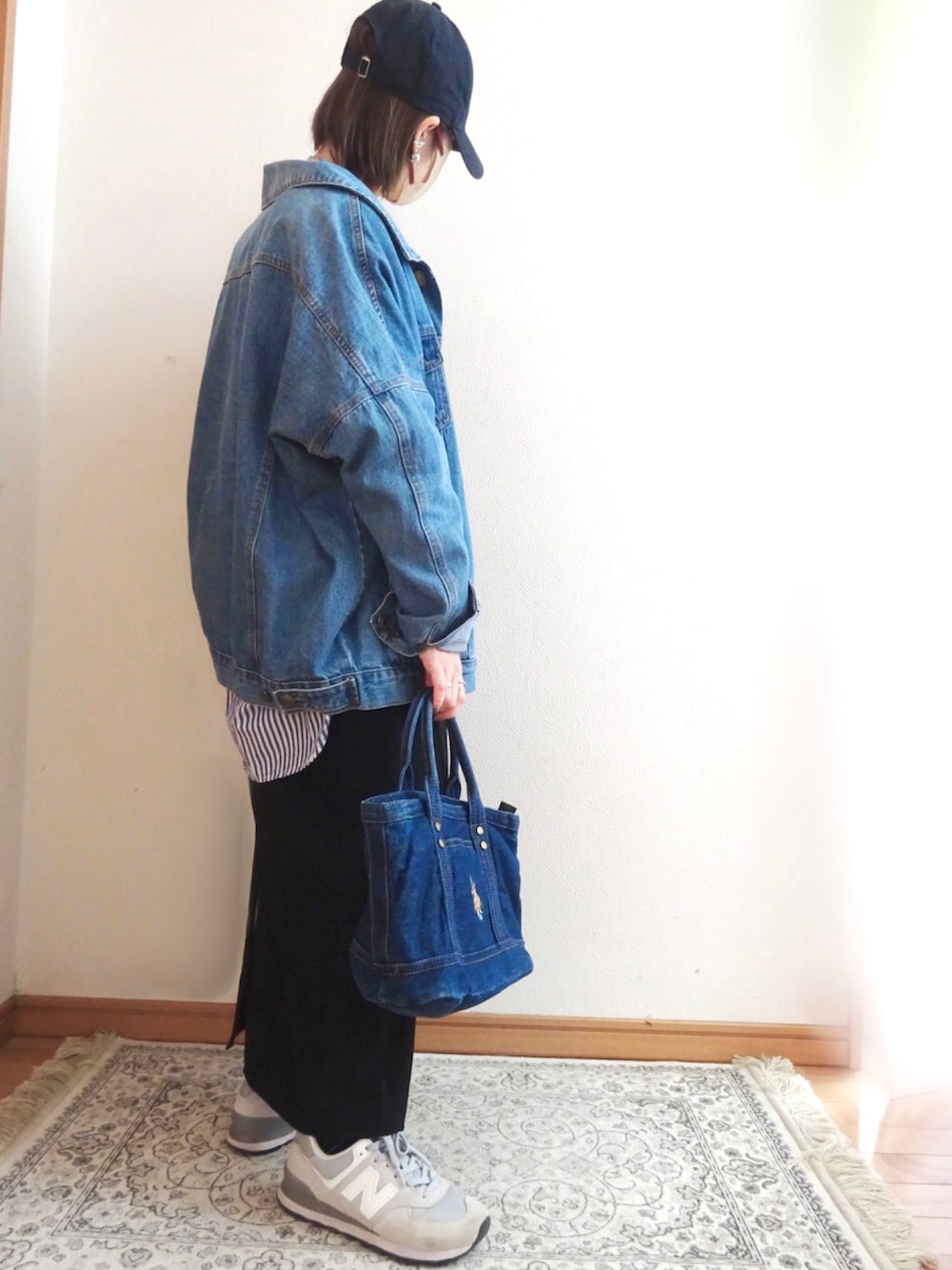 ブルー系のデニムジャケット、ブラック系のワンピース、ブルー系のシャツ/ブラウスを着用したレディースの春コーディネートの2枚目の写真