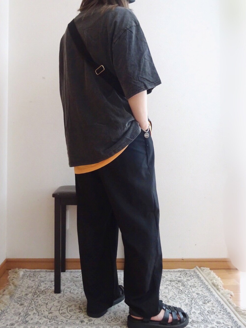 ブラック系のTシャツ/カットソー、オレンジ系のTシャツ/カットソー、ブラック系のサンダルを着用したレディースの春コーディネートの2枚目の写真