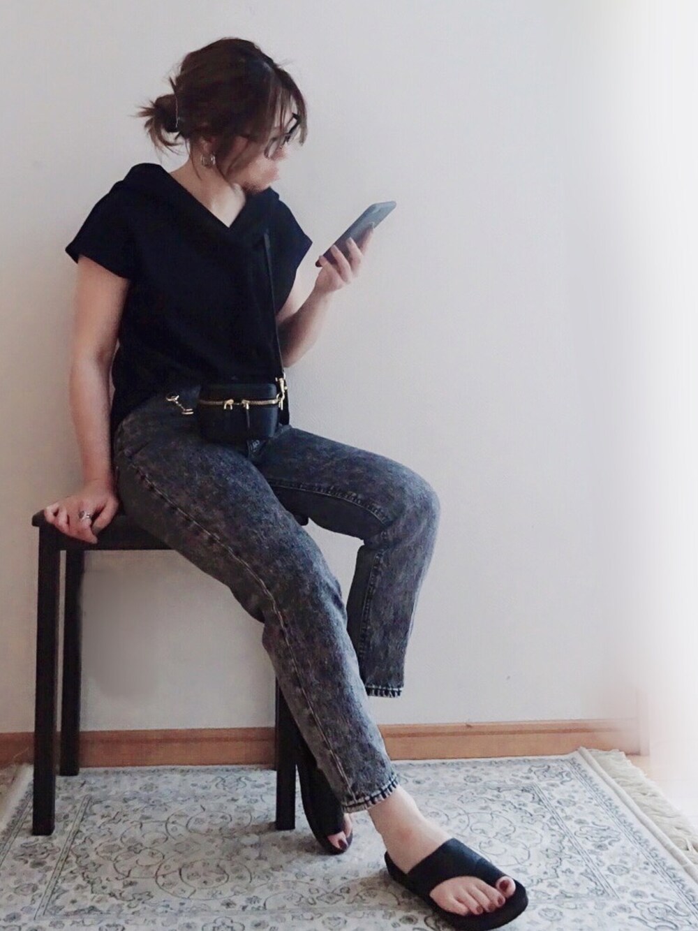 ブラック系のパーカー、ブラック系のデニムパンツ、ブラック系のサンダルを着用したレディースの春コーディネートの2枚目の写真