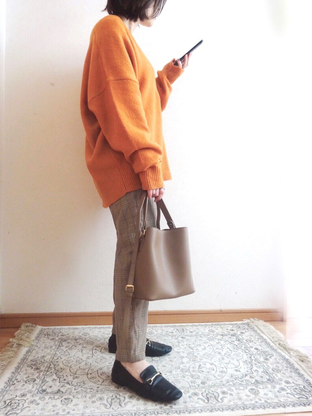 オレンジ系のニット/セーター、その他のその他パンツ、ブラック系のローファーを着用したレディースの秋コーディネートの2枚目の写真