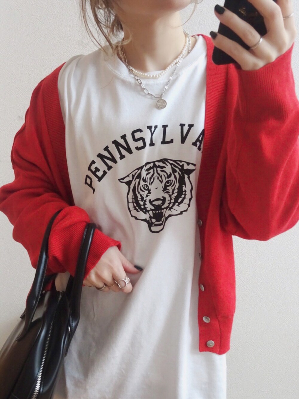 ブラック系のトートバッグ、ホワイト系のTシャツ/カットソー、ブルー系のデニムパンツを着用したレディースの冬コーディネートの2枚目の写真