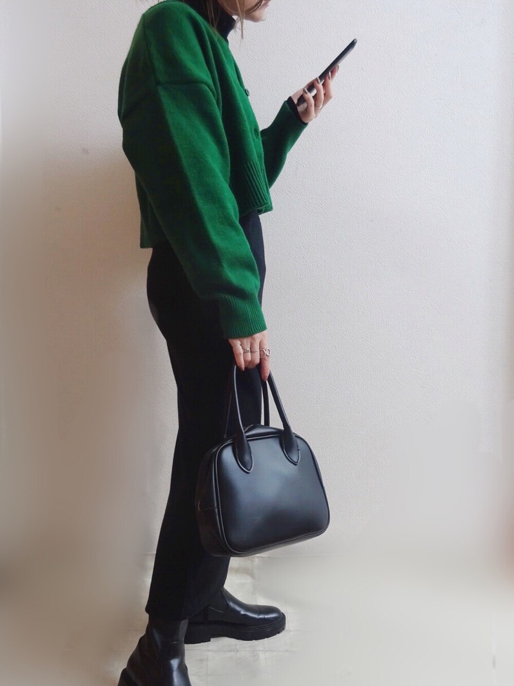 グリーン系のカーディガン/ボレロ、ブラック系のブーツ、ブラック系のトートバッグを着用したレディースの冬コーディネートの3枚目の写真
