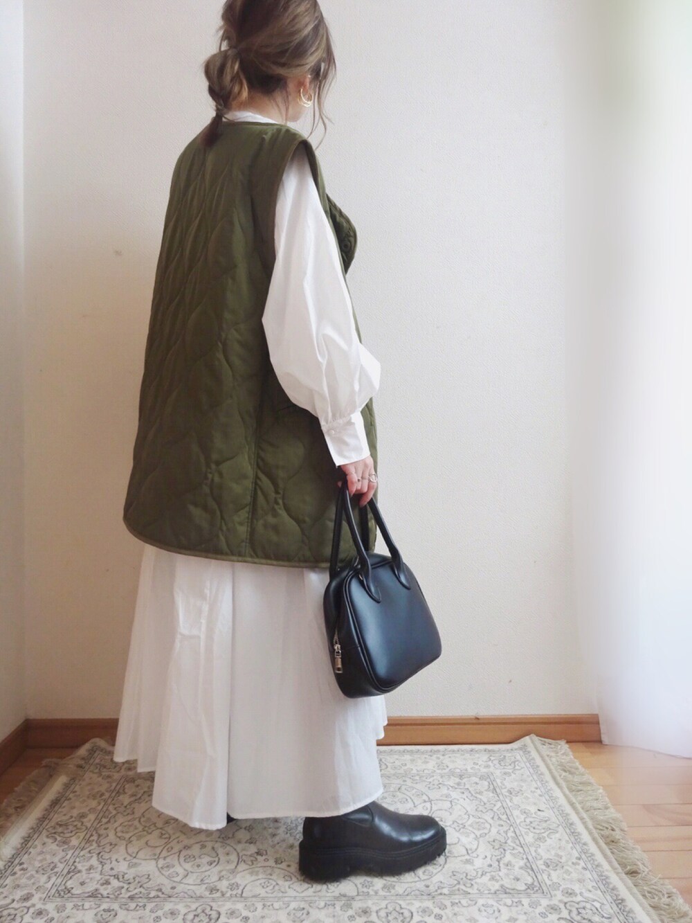 グリーン系のベスト、ホワイト系のシャツワンピース、ブラック系のトートバッグを着用したレディースの春コーディネートの2枚目の写真