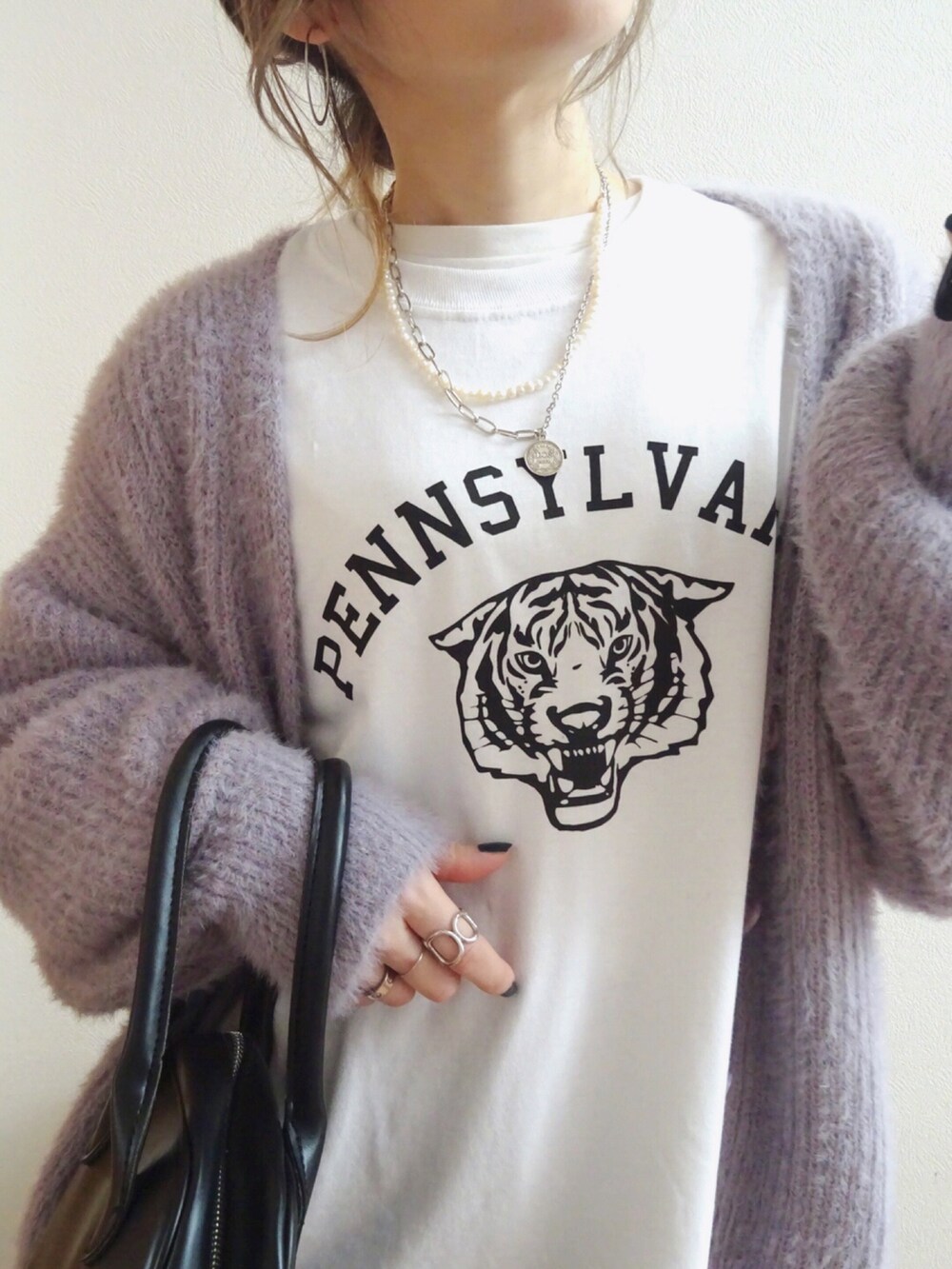 パープル系のカーディガン/ボレロ、ホワイト系のTシャツ/カットソー、ブラック系のトートバッグを着用したレディースの冬コーディネートの2枚目の写真