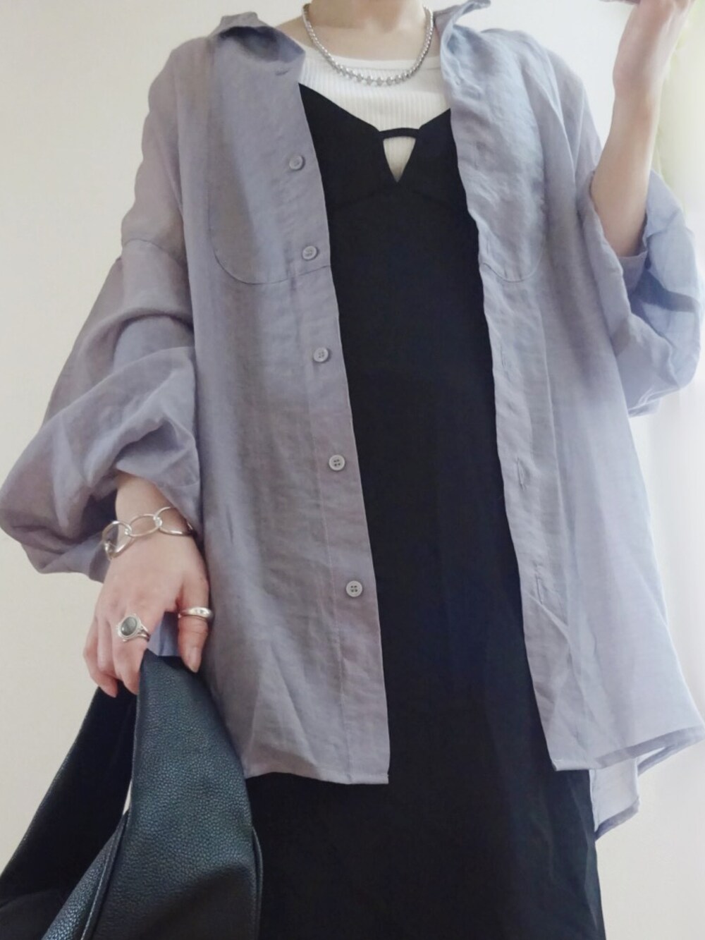 ブラック系のジャンパースカート、パープル系のシャツ/ブラウス、ブラック系のショルダーバッグを着用したレディースの春コーディネートの2枚目の写真