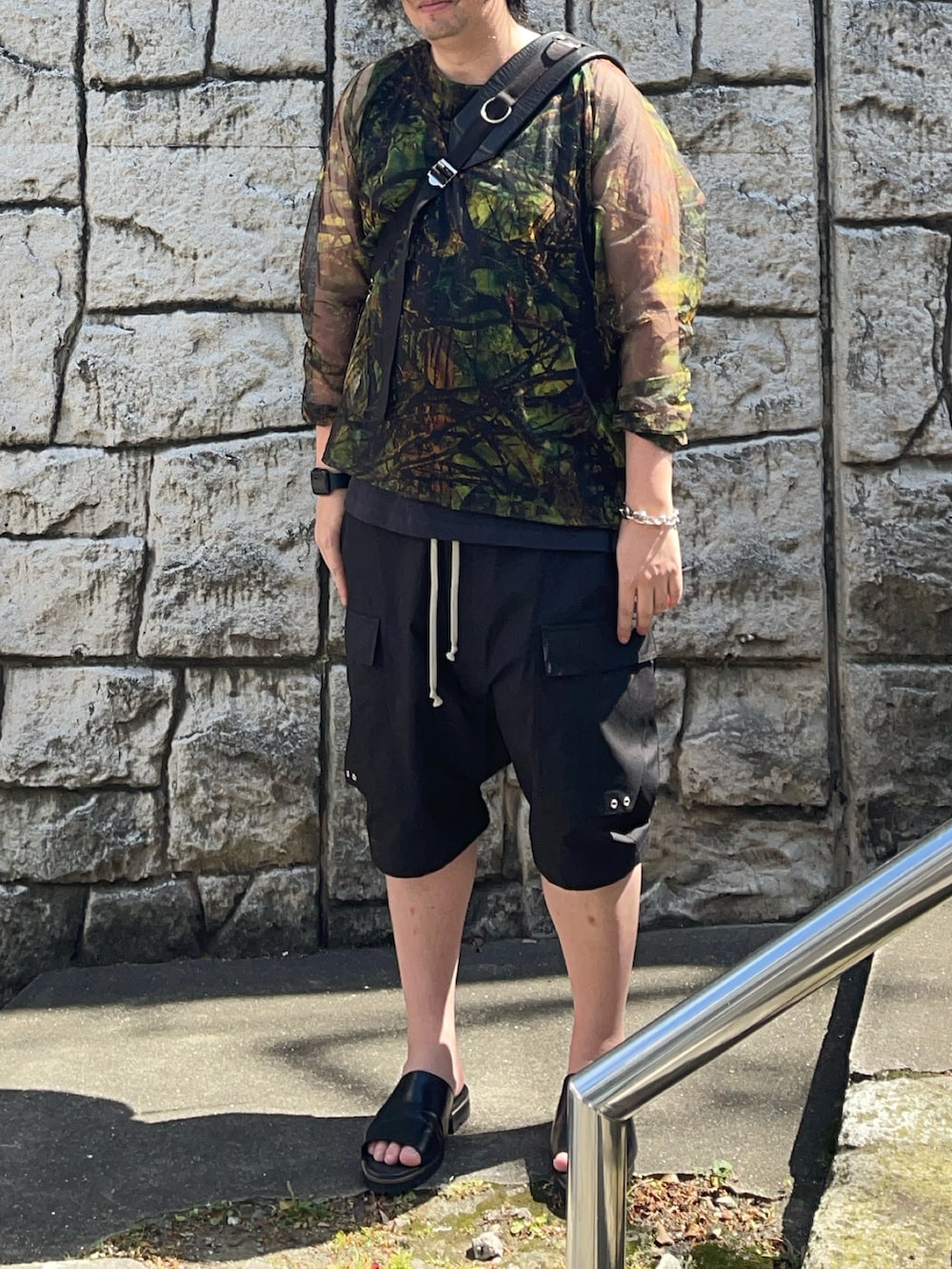 グリーン系のその他トップス、ブラック系のタンクトップ、ブラック系のカーゴパンツを着用したメンズの春コーディネートの2枚目の写真