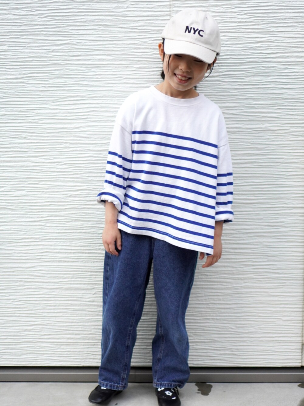 ブルー系のデニムパンツ、ブラック系のバレエシューズ、ブルー系のTシャツ/カットソーを着用したキッズの冬コーディネートの2枚目の写真