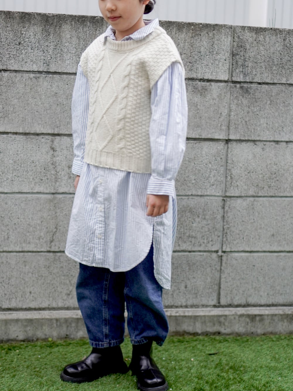 ブルー系のシャツワンピース、ベージュ系のベストを着用したキッズの冬コーディネートの2枚目の写真