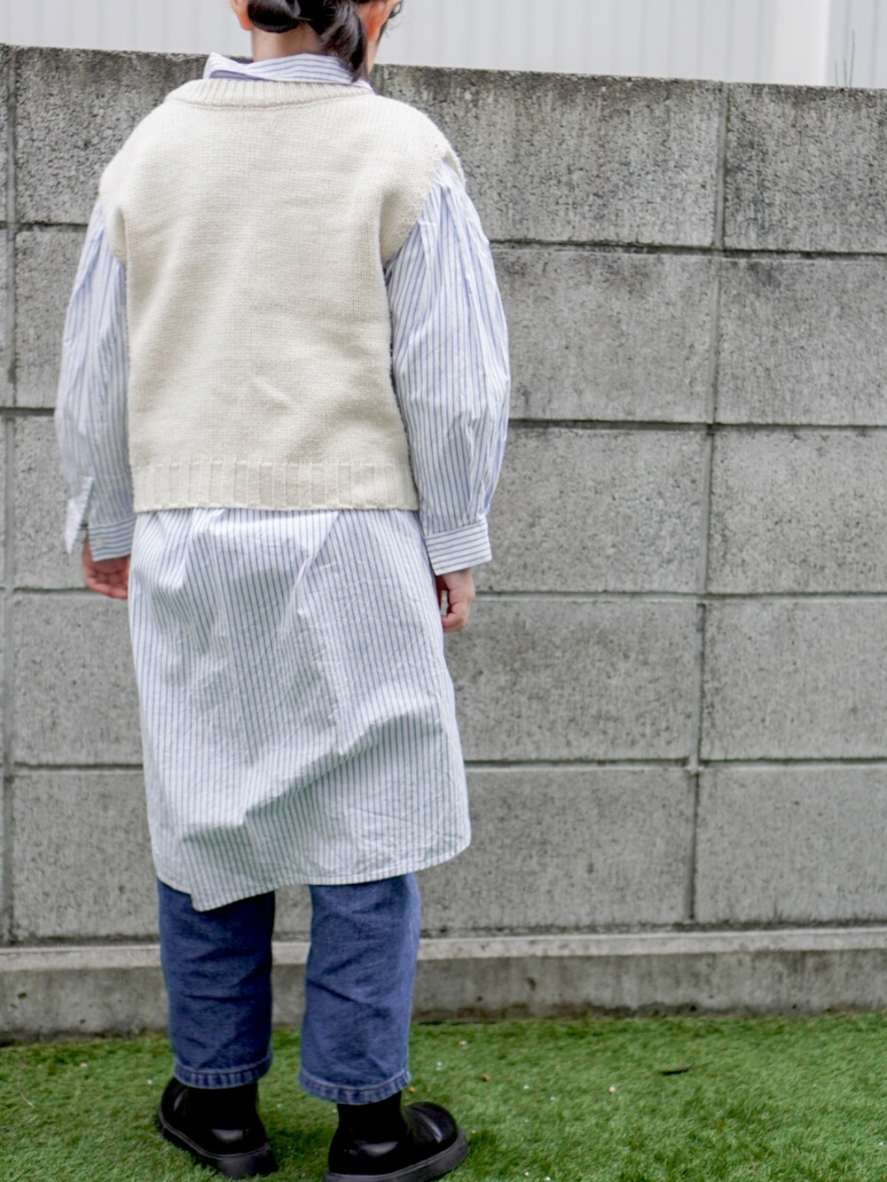 ブルー系のシャツワンピース、ベージュ系のベストを着用したキッズの冬コーディネートの3枚目の写真