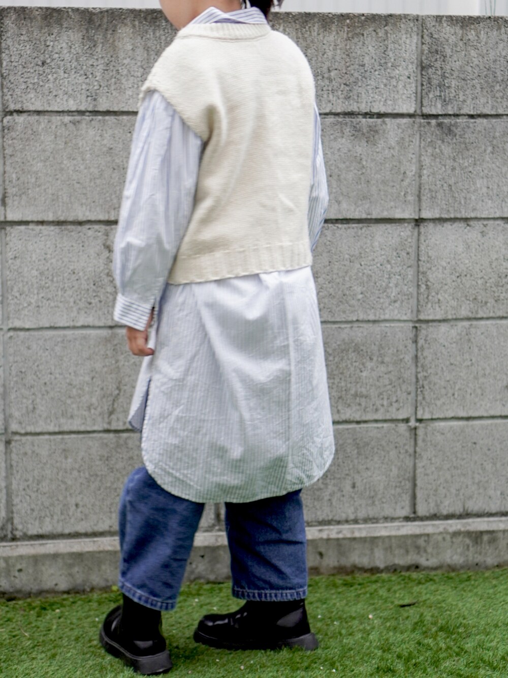 ブルー系のシャツワンピース、ベージュ系のベストを着用したキッズの冬コーディネートの4枚目の写真