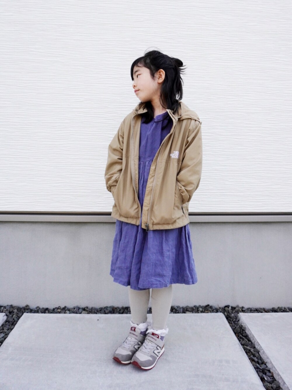 ブルー系のワンピース、グレー系のスニーカー、ベージュ系のマウンテンパーカーを着用したキッズの冬コーディネートの2枚目の写真