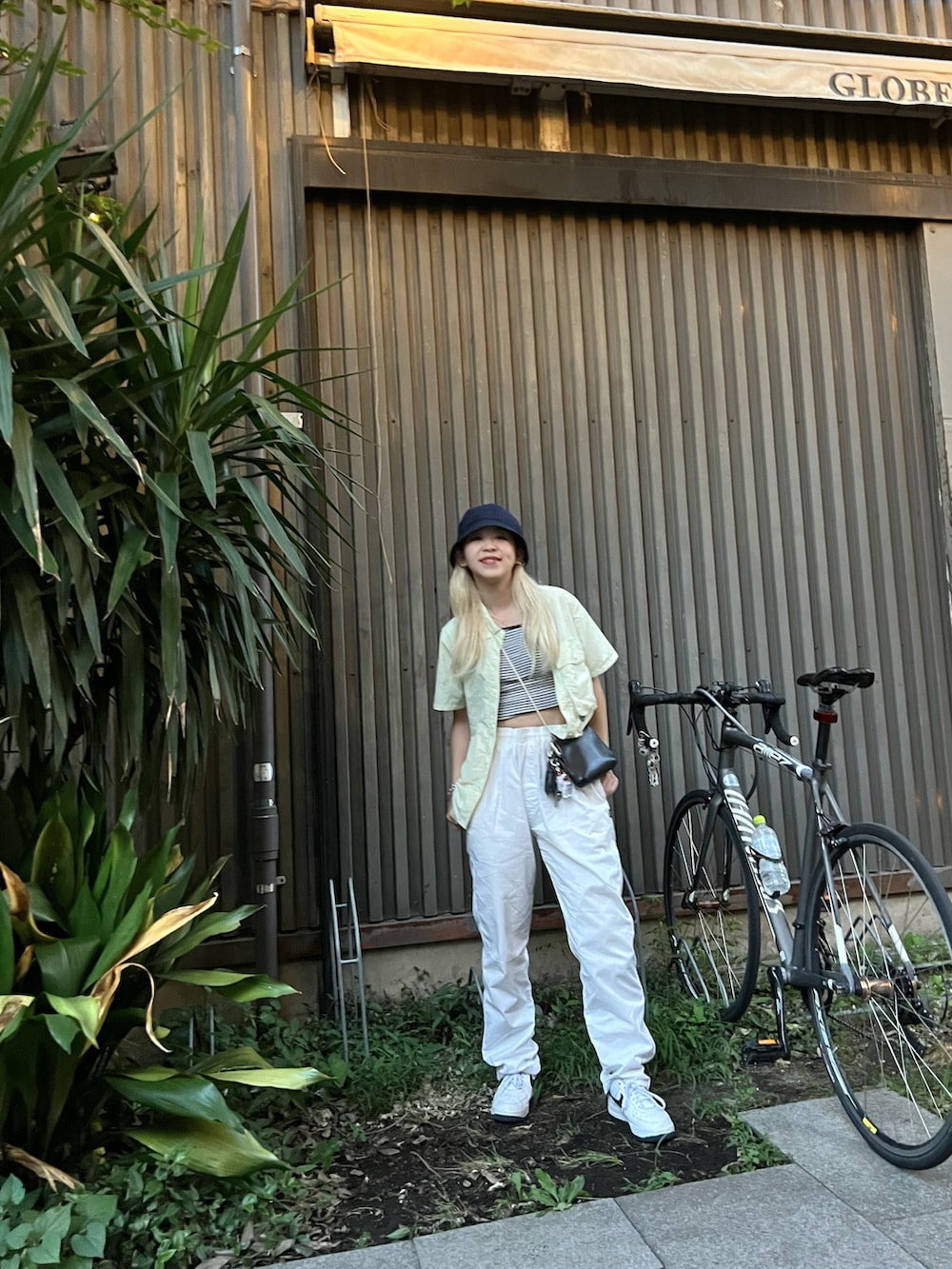 「stussyコーデ、stussy、stussy women、ストリートコーデ、ストリート女子、ストリートMIX、ラクチンコーデ、ホワイトパンツ、diaspora skateboards、バケットハット、蛍光カラー、ホワイトコーデ、ストライプ、キャミソール、シャツコーデ」｜「Diaspora Skateboardsのアイテム（帽子、ブルー系）」を使った、Mikuさん（レディース・158cm）の夏コーディネートの2枚目の写真