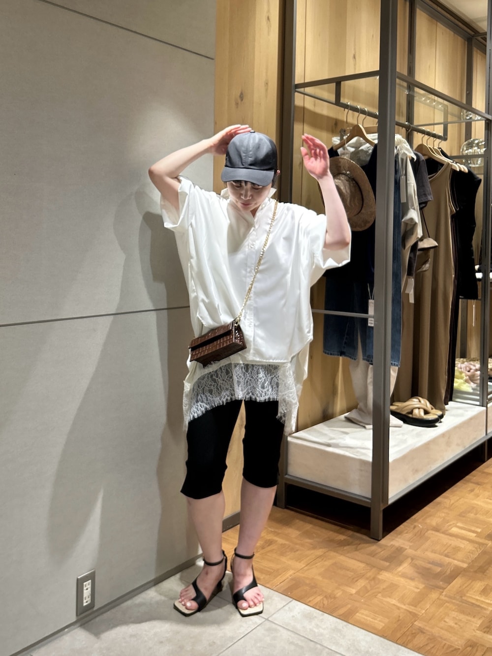ブラウン系のショルダーバッグ、ホワイト系のシャツ/ブラウス、ホワイト系のシャツ/ブラウスを着用したレディースの夏コーディネートの3枚目の写真