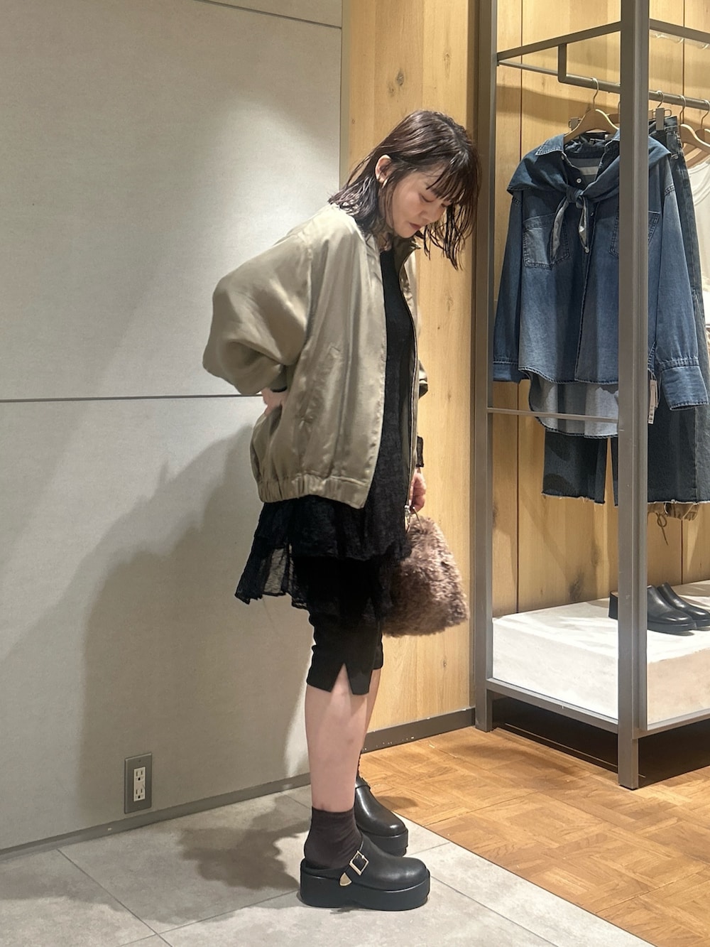 ブラック系のワンピース、グリーン系のブルゾン、ブラック系のその他パンツを着用したレディースの秋コーディネートの2枚目の写真