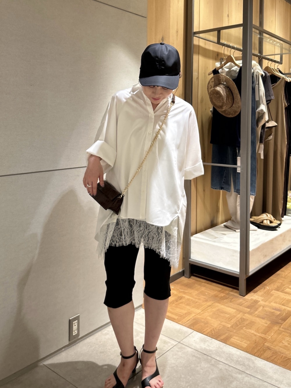 ブラウン系のショルダーバッグ、ホワイト系のシャツ/ブラウス、ホワイト系のシャツ/ブラウスを着用したレディースの夏コーディネートの2枚目の写真
