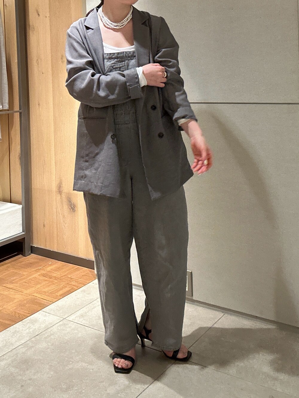 グレー系のサロペット/オーバーオール、グレー系のベスト、ブラック系のサンダルを着用したレディースの春コーディネートの4枚目の写真