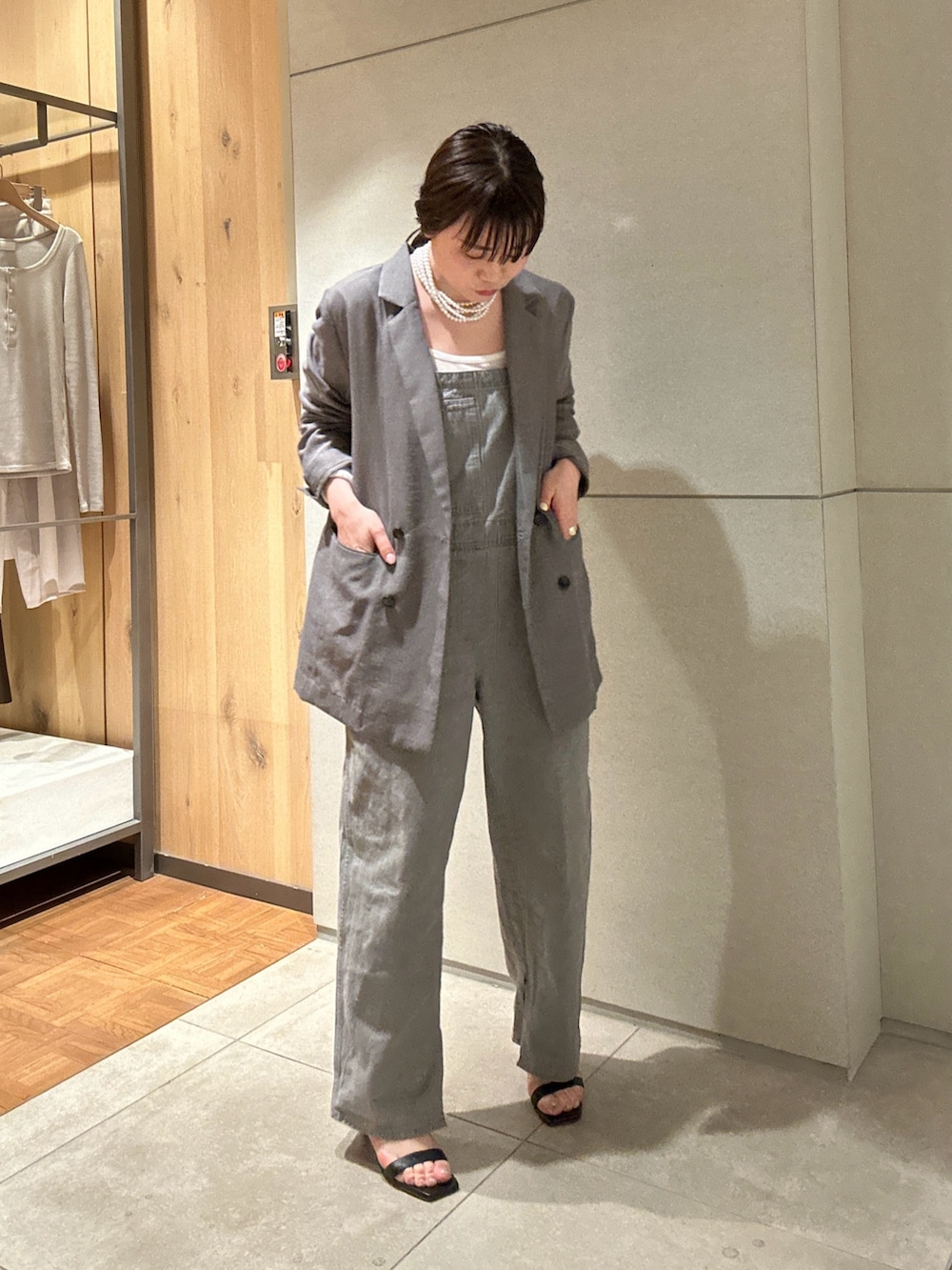 グレー系のサロペット/オーバーオール、グレー系のベスト、ブラック系のサンダルを着用したレディースの春コーディネートの3枚目の写真