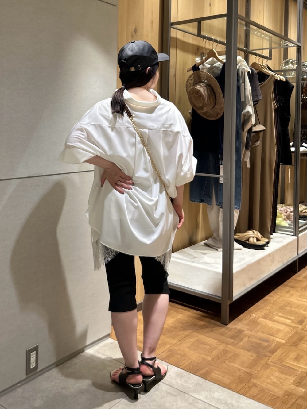 ブラウン系のショルダーバッグ、ホワイト系のシャツ/ブラウス、ホワイト系のシャツ/ブラウスを着用したレディースの夏コーディネートの4枚目の写真