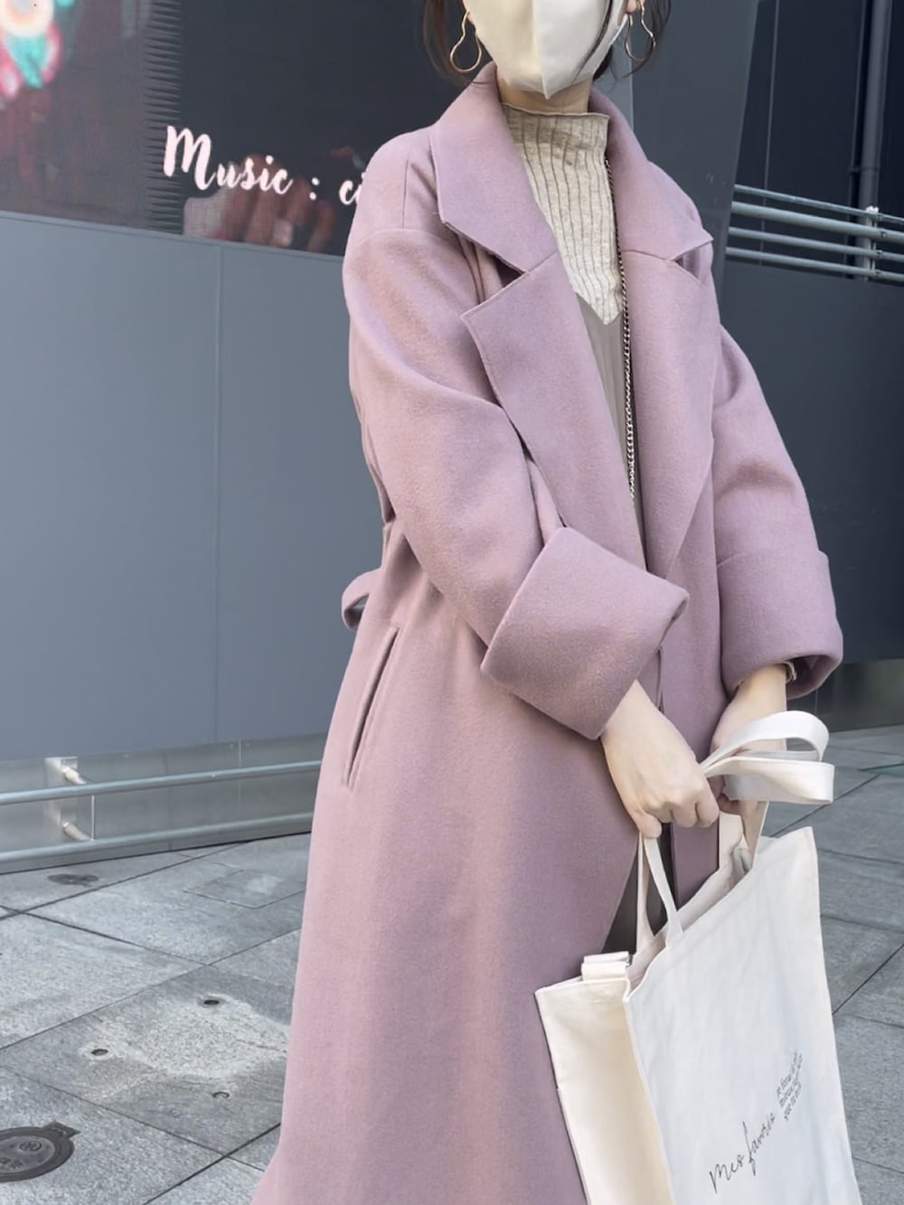 ピンク系のチェスターコート、ブラウン系のワンピースを着用したレディースの秋コーディネートの3枚目の写真