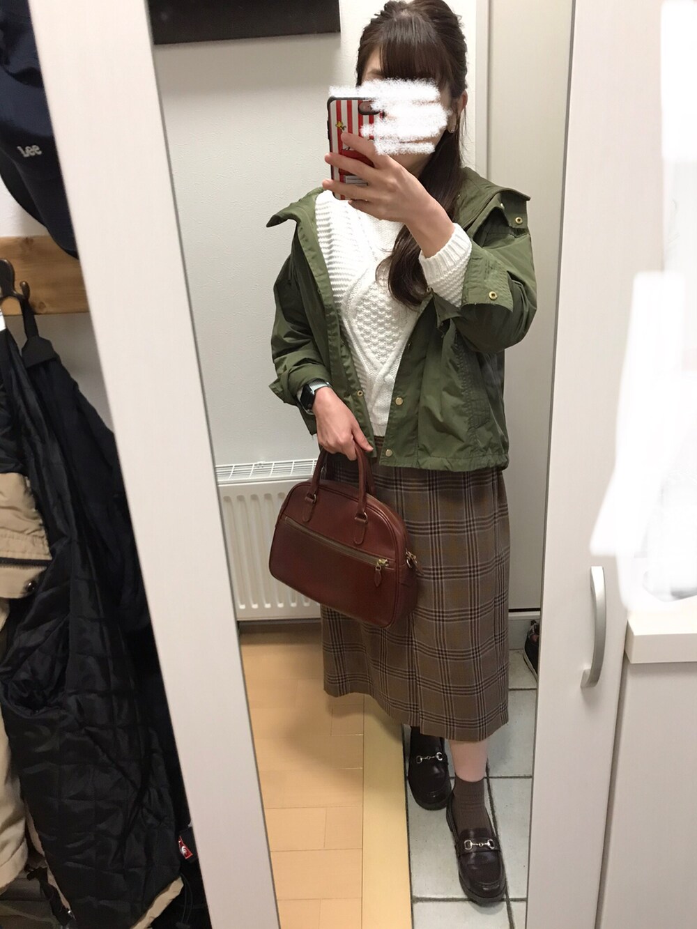 ブラウン系のボストンバッグ、ブラウン系のスカート、ブラウン系のローファーを着用したレディースの秋コーディネートの2枚目の写真