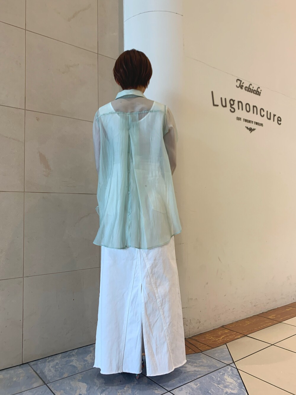 グリーン系のシャツ/ブラウス、ホワイト系のスカート、ホワイト系のパンプスを着用したレディースの春コーディネートの3枚目の写真