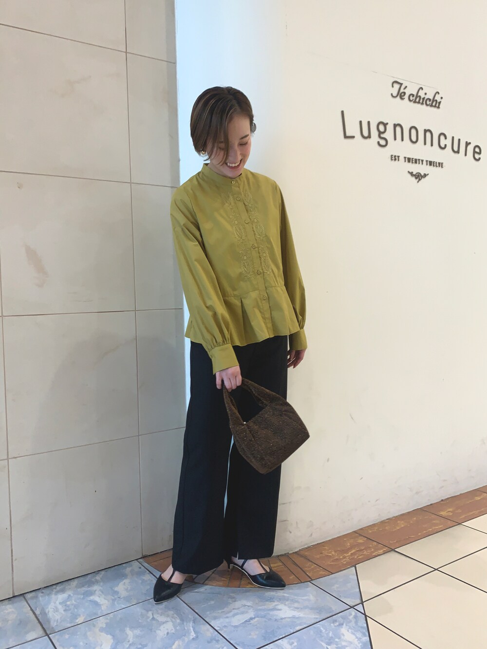 グリーン系のシャツ/ブラウス、ブラック系のその他パンツ、ブラック系のパンプスを着用したレディースの秋コーディネートの2枚目の写真