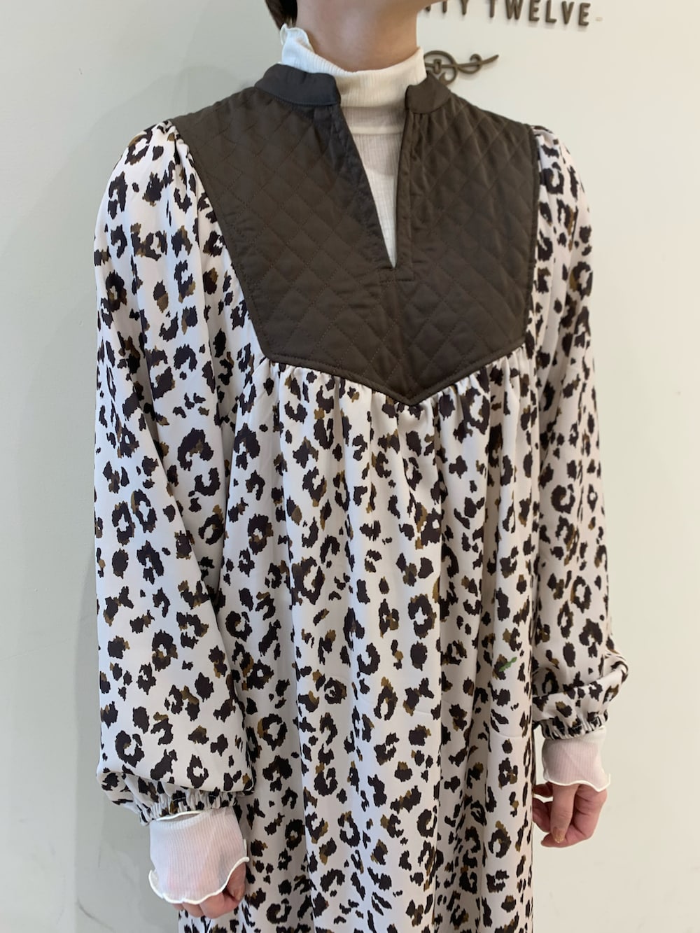 ブラウン系のワンピース、ホワイト系のその他パンツ、ホワイト系のTシャツ/カットソーを着用したレディースの冬コーディネートの2枚目の写真