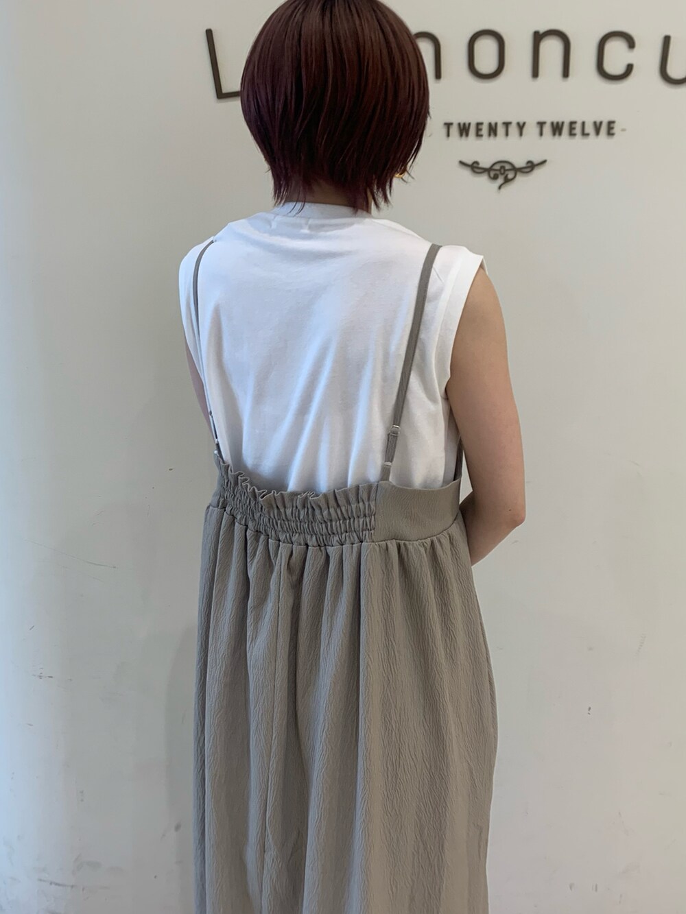 ブラウン系のワンピース、ホワイト系のTシャツ/カットソー、ブラック系のハンドバッグを着用したレディースの夏コーディネートの3枚目の写真