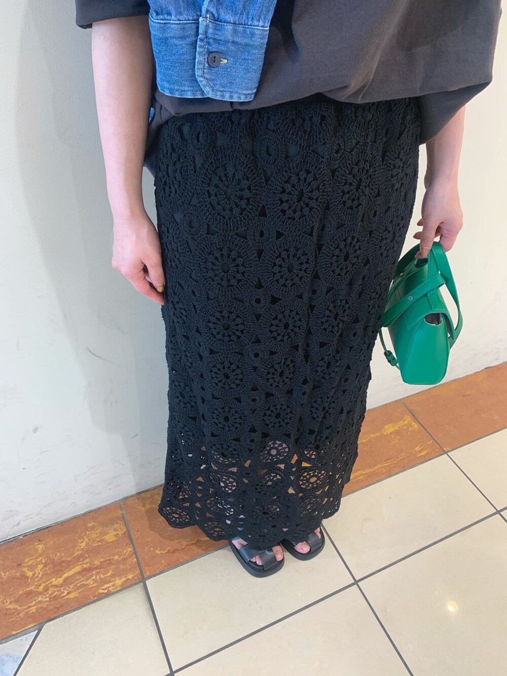 ブラック系のスカート、グレー系のTシャツ/カットソー、ブルー系のシャツ/ブラウスを着用したレディースの春コーディネートの2枚目の写真