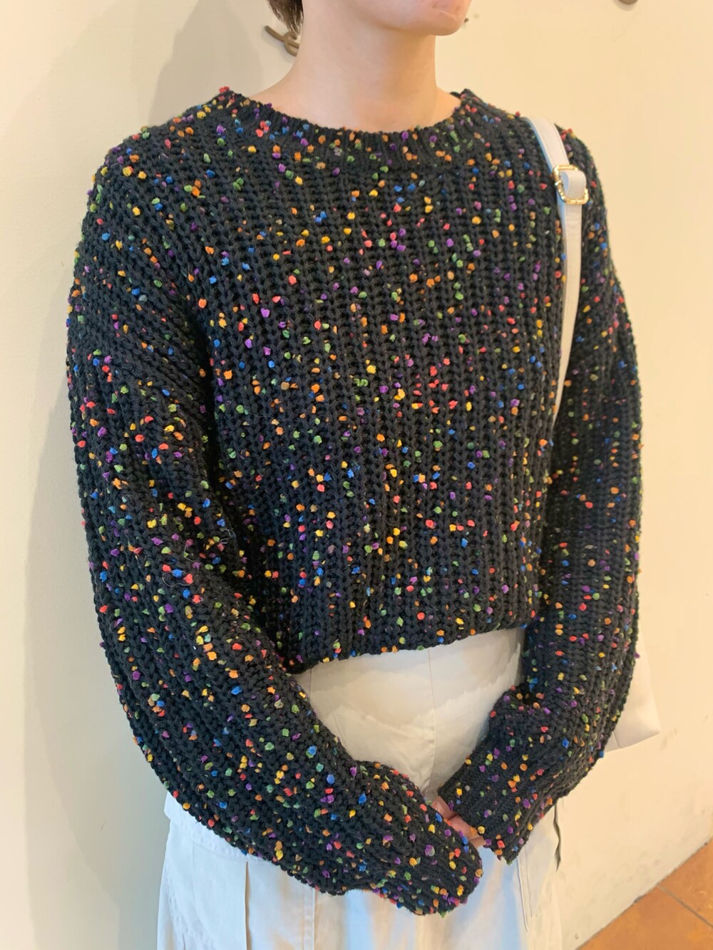 ブラック系のニット/セーター、ホワイト系のスカート、ブラック系のブーツを着用したレディースの冬コーディネートの4枚目の写真