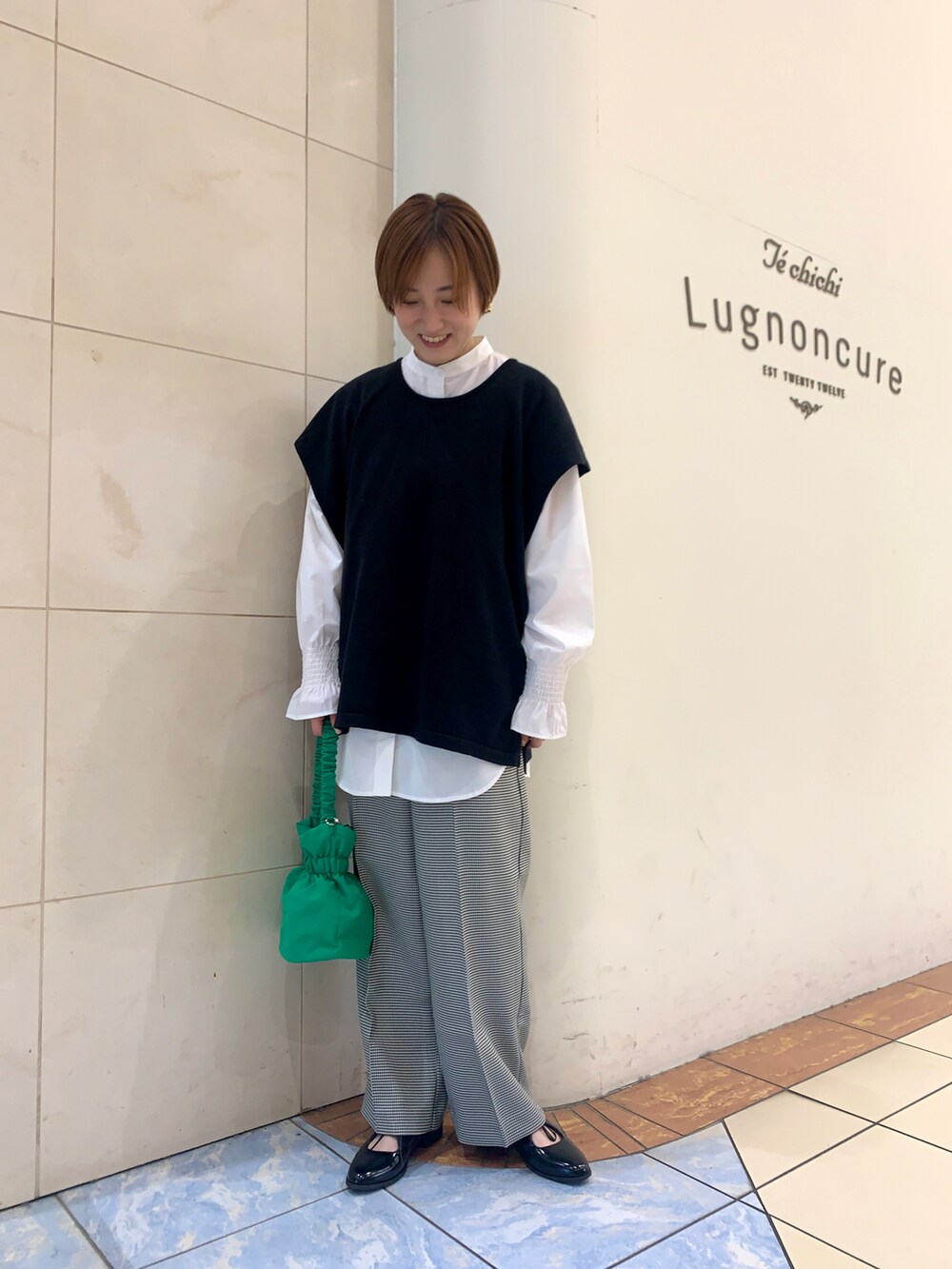 ホワイト系のシャツ/ブラウス、ブラック系のニット/セーター、ホワイト系のその他パンツを着用したレディースの春コーディネートの2枚目の写真