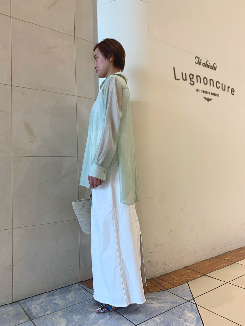 グリーン系のシャツ/ブラウス、ホワイト系のスカート、ホワイト系のパンプスを着用したレディースの春コーディネートの2枚目の写真