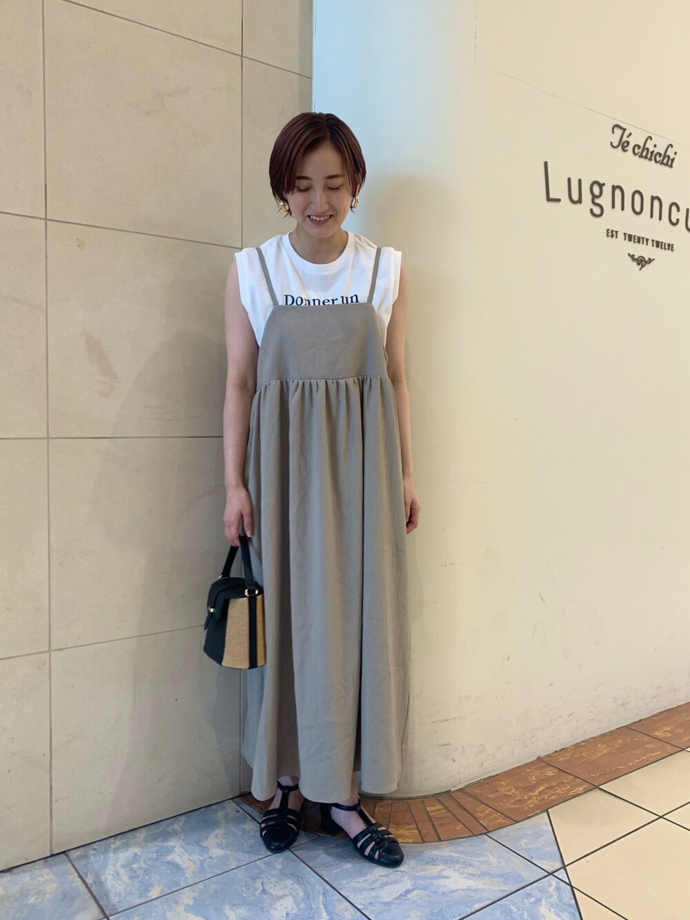 ブラウン系のワンピース、ホワイト系のTシャツ/カットソー、ブラック系のハンドバッグを着用したレディースの夏コーディネートの2枚目の写真