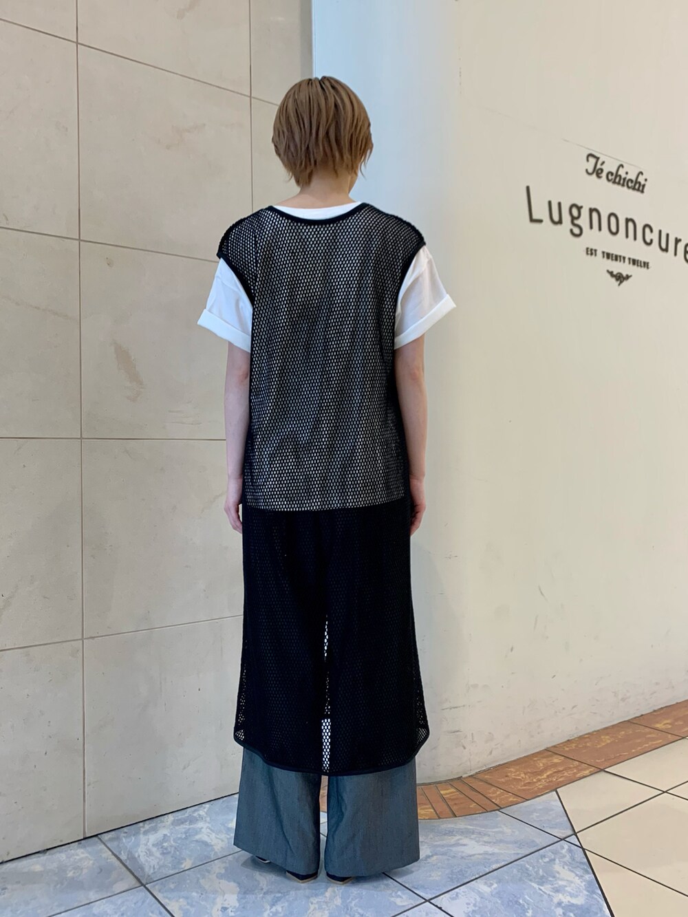 ブラック系のデニムパンツ、ブラック系のサンダル、ブラック系のニット/セーターを着用したレディースの春コーディネートの2枚目の写真