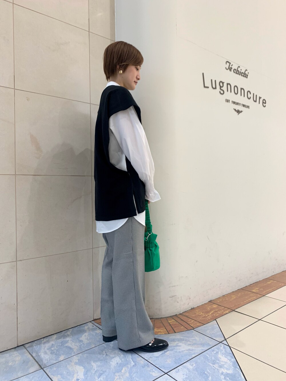 ホワイト系のシャツ/ブラウス、ブラック系のニット/セーター、ホワイト系のその他パンツを着用したレディースの春コーディネートの3枚目の写真