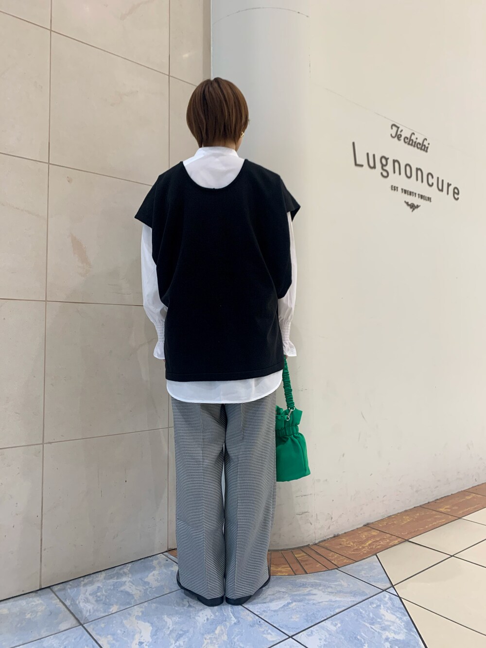 ホワイト系のシャツ/ブラウス、ブラック系のニット/セーター、ホワイト系のその他パンツを着用したレディースの春コーディネートの4枚目の写真