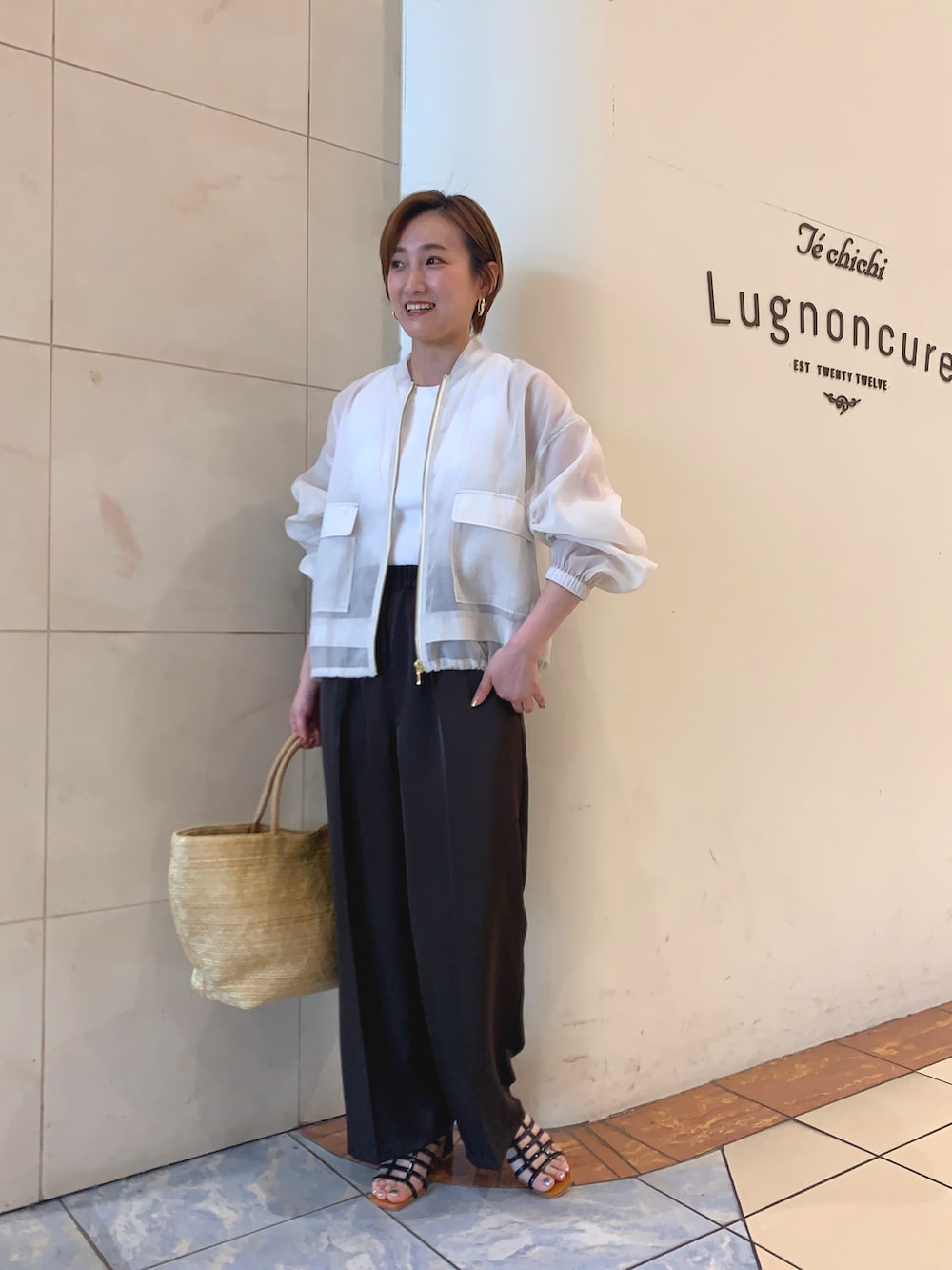 ホワイト系のニット/セーター、ホワイト系のブルゾン、グレー系のその他パンツを着用したレディースの夏コーディネートの2枚目の写真