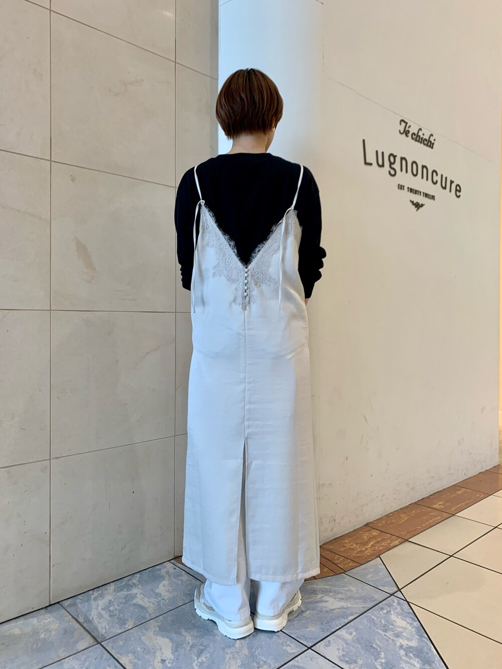 ホワイト系のワンピース、ブラック系のTシャツ/カットソー、ブラック系のハンドバッグを着用したレディースの春コーディネートの3枚目の写真