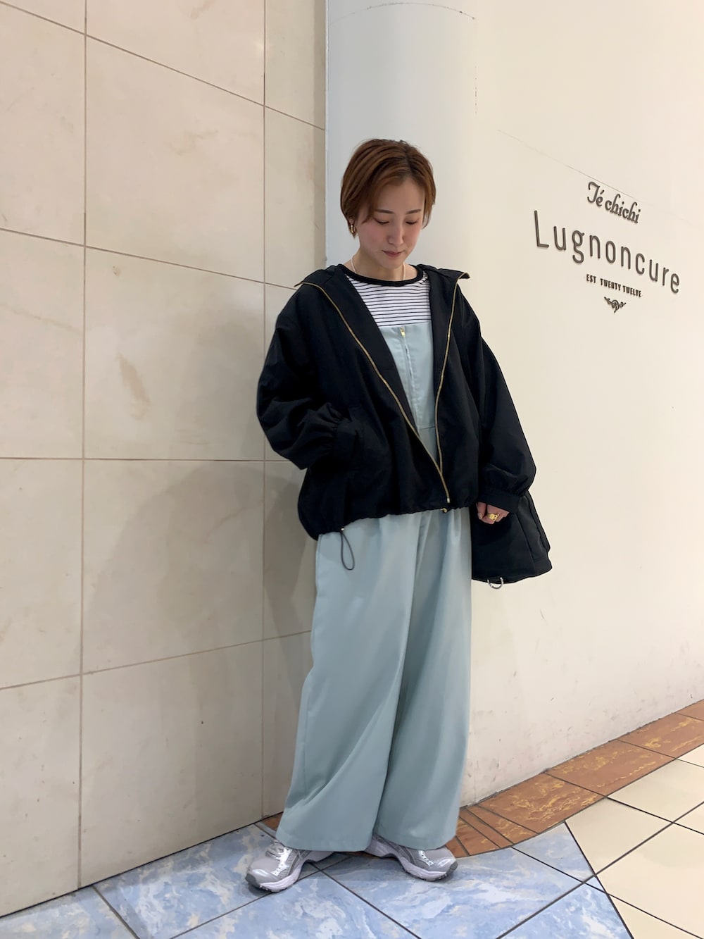 ブラック系のブルゾン、グリーン系のサロペット/オーバーオール、ホワイト系のTシャツ/カットソーを着用したレディースの春コーディネートの2枚目の写真