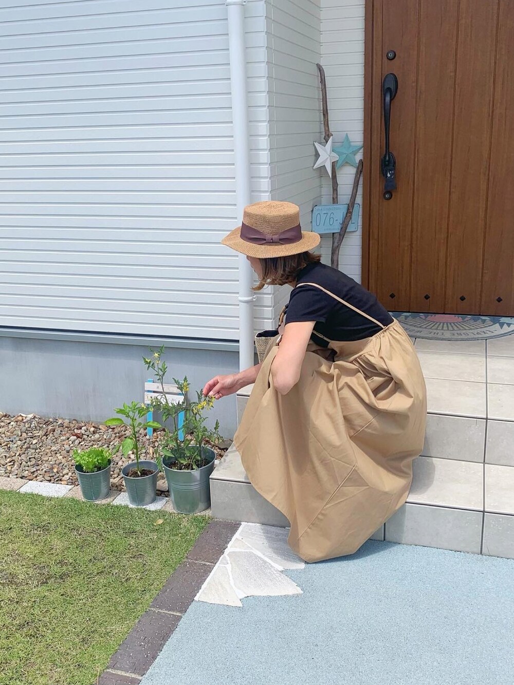 ベージュ系のスカート、ブラック系のスニーカーを着用したレディースの春コーディネートの3枚目の写真